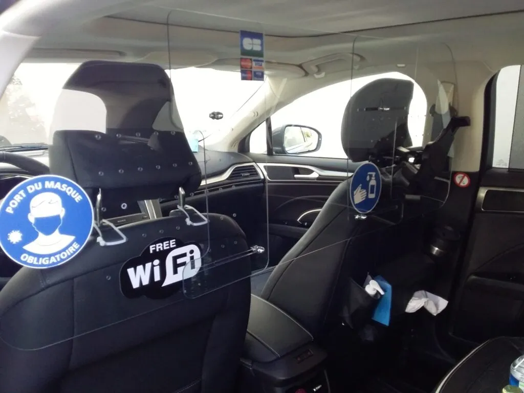 hygienskydd av transparent plast monterat i baksätet på en taxi bil