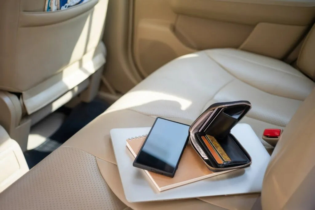 Utsikt fra utsiden av bilen på verdisaker lommebok, veske laptop eller datamaskin notatbok, kredittkort og mobiltelefon, Windows som er rullet ned er åpne invitasjoner for tyver å gå inn i bilen