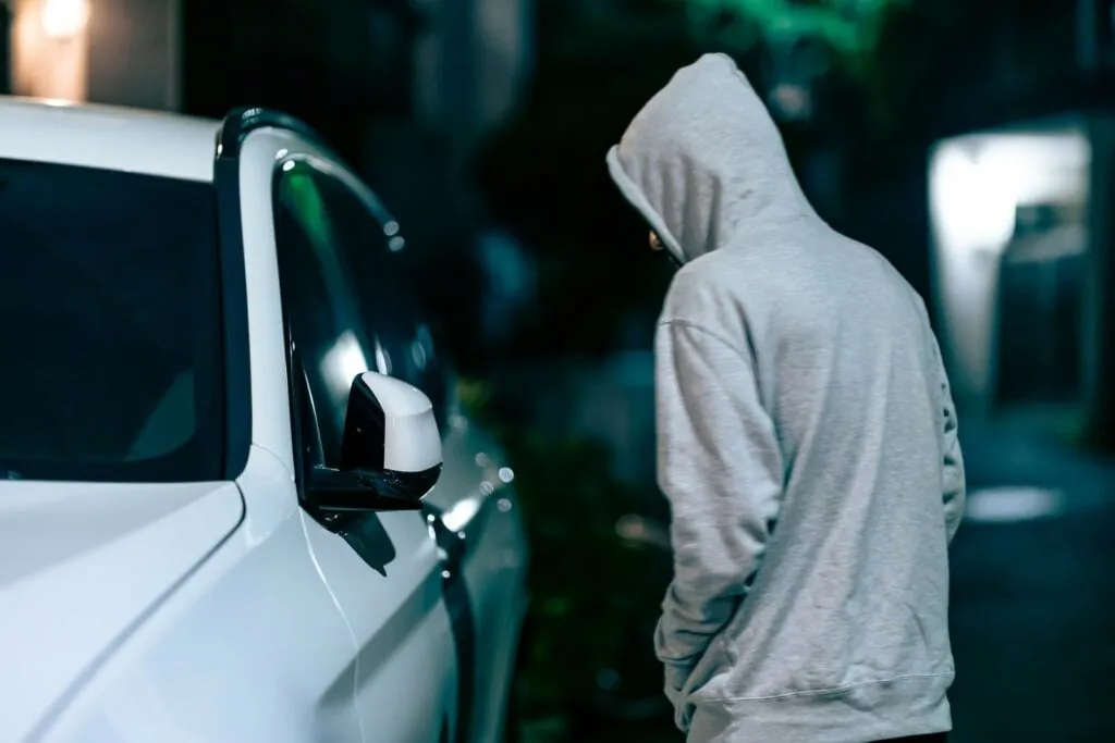 Thief in hoodie trying to steal the car